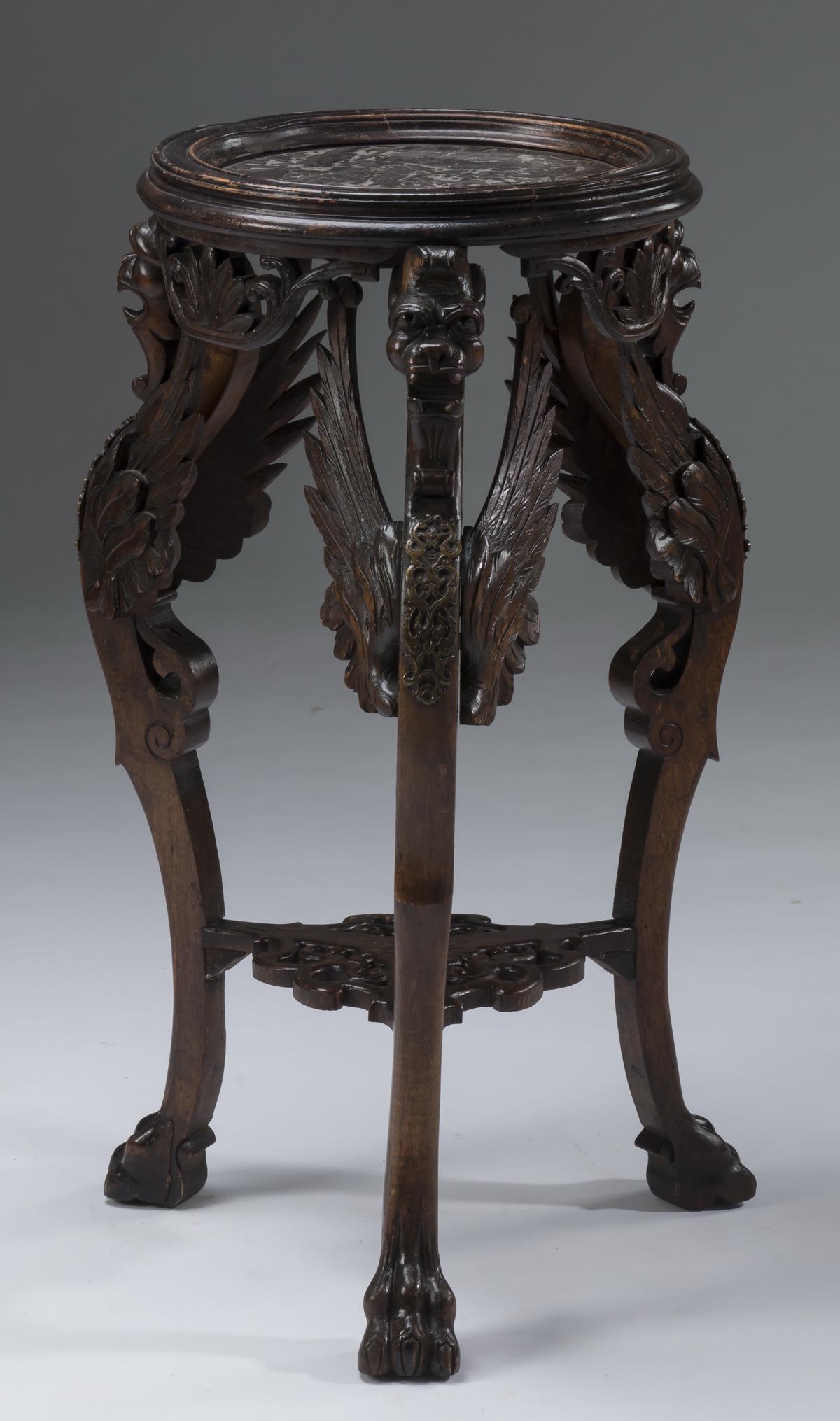 Carved walnut & marble winged griffin gueridon, 31"h: Carved walnut and marble gueridon, having a circular black marble top captured in a molded frame resting on three winged griffin monopodia, ending in paw feet and joined by a pierced foliate lower she