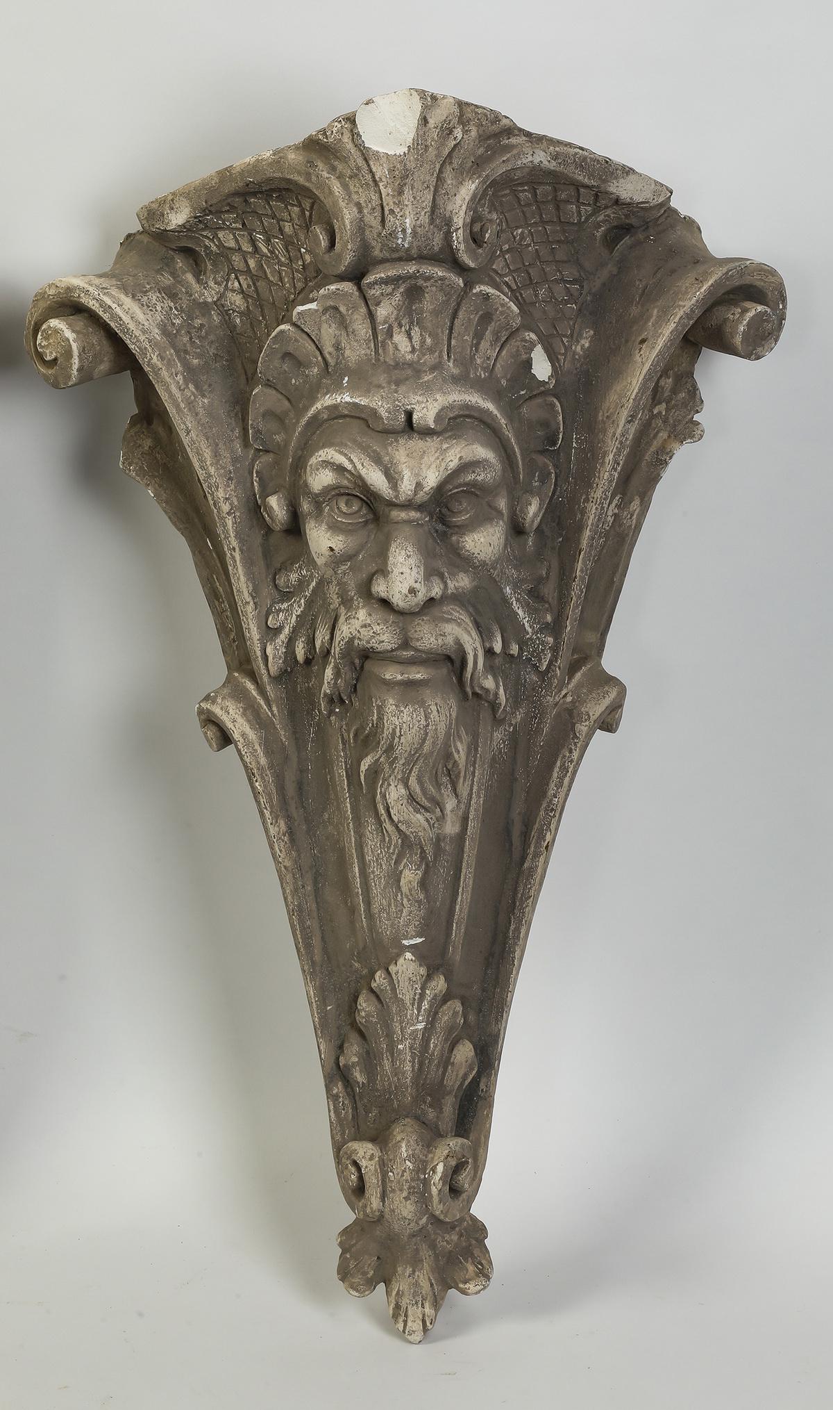 Cast plaster Green Man architectural element, 30"h: Cast plaster architectural element, having a Green Man mask flanked by scrollwork, terminating in acanthus, 29.5"h x 17.5"w x 9"d.