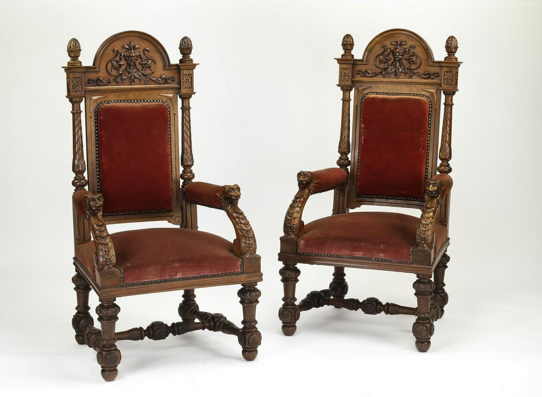 (2) French walnut and velvet upholstered armchairs: (2) French walnut and velvet upholstered side chairs in the Renaissance taste, early 20th century, having an arched crest centering a Green Man mask flanked by finials, over a rectangular back and tra