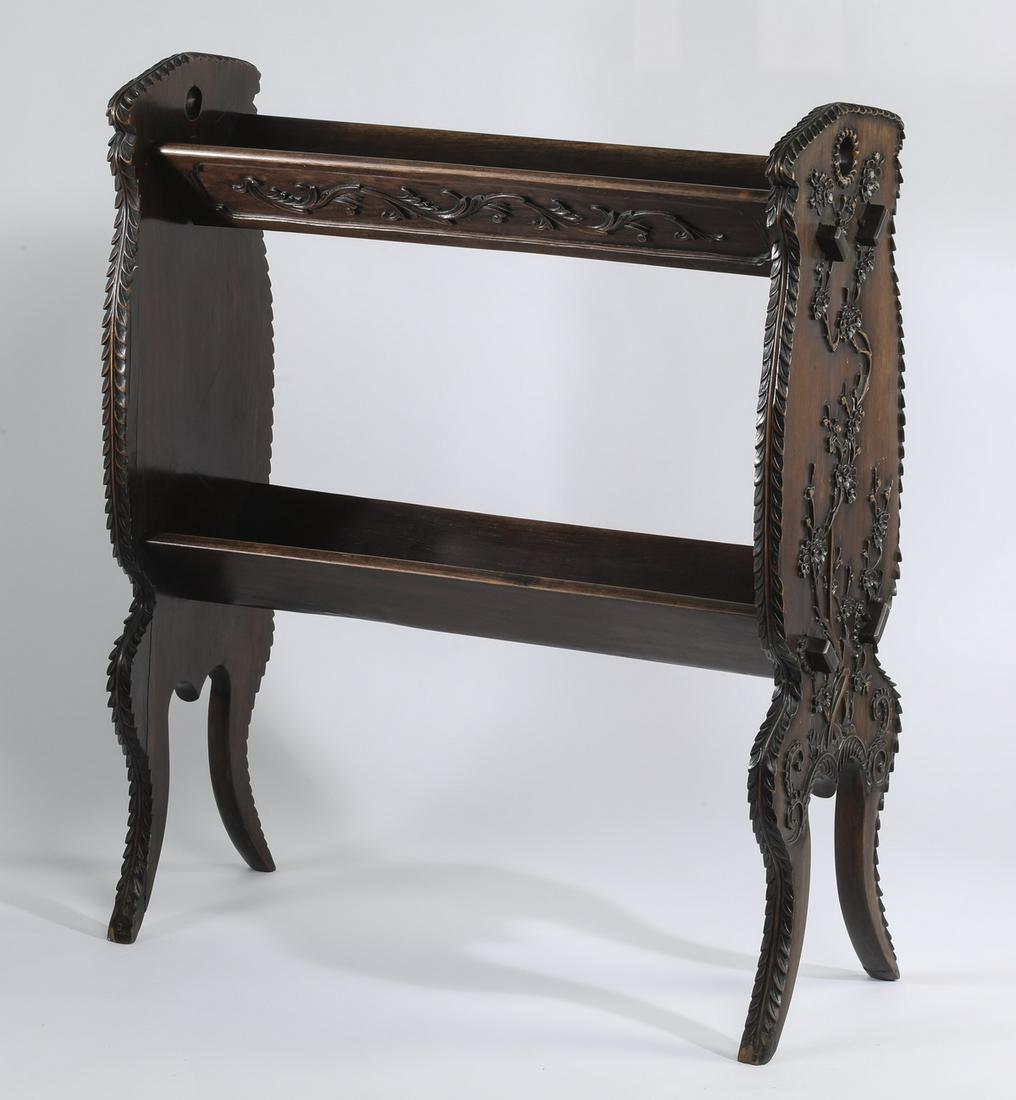 19th c. Aesthetic Movement walnut canterbury, 36"h: Aesthetic Movement carved walnut canterbury, late 19th century, having two trough shelves joined by lyre form supports, relief carved with prunus branches, the whole rising on outswept legs, 36"h x 31