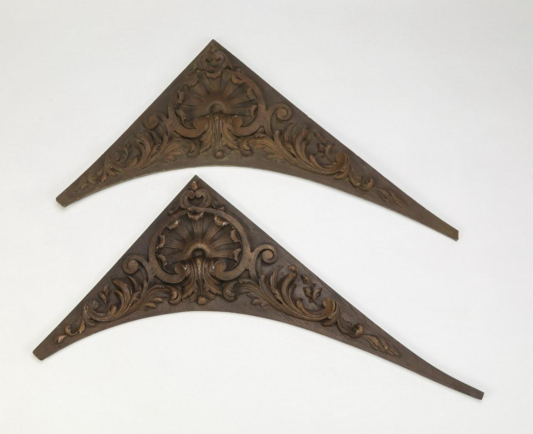 (2) Cast resin architectural elements, 29"l: Pair of cast resin architectural elements, of triangular form centering a foliate fan framed by 'C' scrolls and acanthus swags, stained a deep sable, 29"l x 18.5"w x .75"d.