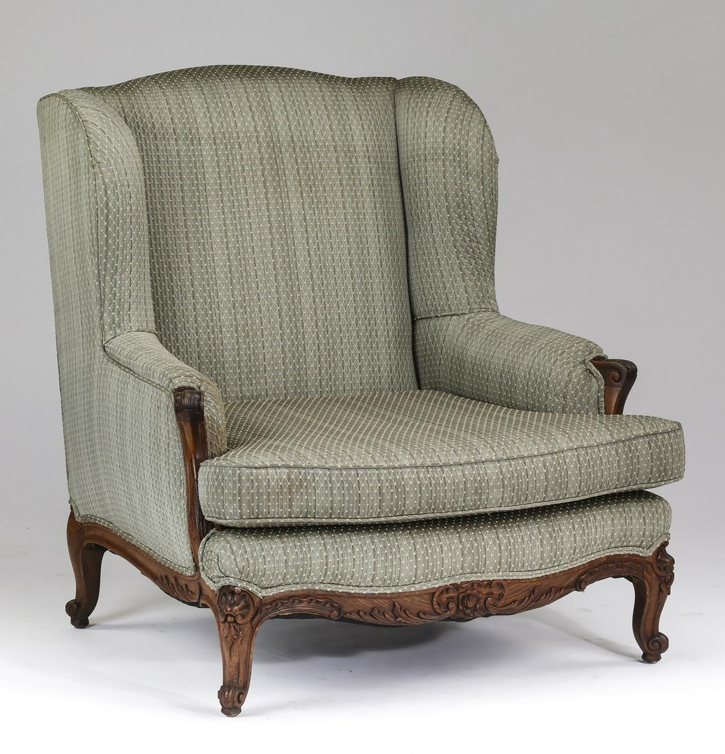 French Provincial style upholstered wingback chair: French Provincial style wingback chair, having an arched back upholstered in a sage jacquard fabric with a diamond motif, centering the shaped seat flanked by scrolling armrests, the whole rising on c