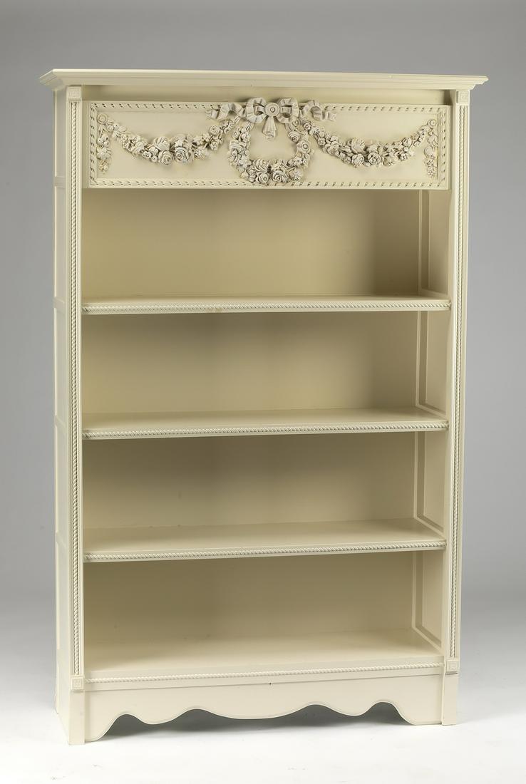 Louis XV style paint-decorated bookcase: Louis XV style paint-decorated bookcase, the cornice above a carved panel with a twist-border centering a ribboned foliate wreath and garlands, above three open shelves, flanked by carved stiles, abov