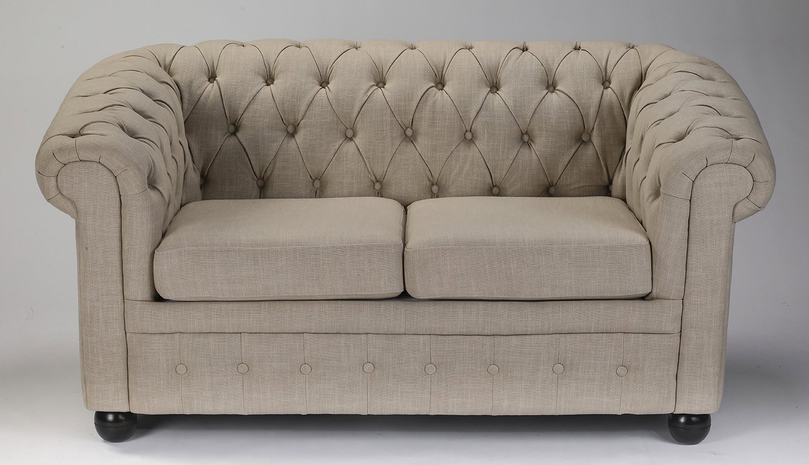 Chesterfield style loveseat in cream linen: Chesterfield style loveseat, upholstered in a neutral cream linen, having a button-tufted back and rolled arms flanking two square drop-in cushions, over a tufted front, all resting on four bun feet, 