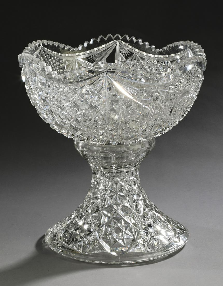 19th c. cut crystal punchbowl on stand: Cut crystal punchbowl on stand, 19th century, having an undulating sawtooth edge, decorating a bowl divided into quarters, having a large shield shape pattern centering a complex hobstar, alternating 