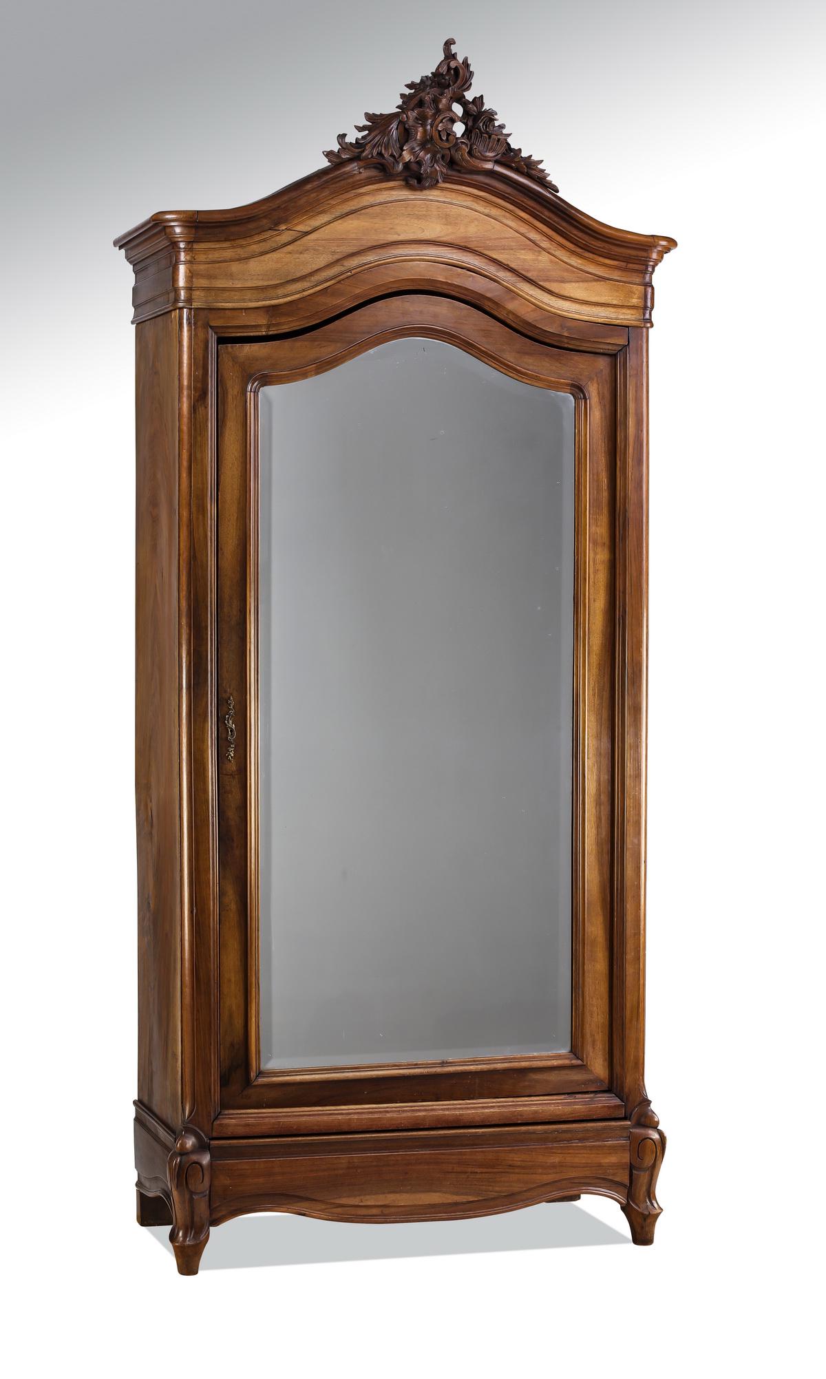 19th c. French Rococo Revival walnut armoire: French Rococo Revival walnut armoire, late 19th century, having a pierced floral rocaille finial surmounting a serpentine cornice above a single arched door mounted with a beveled mirror, terminating 