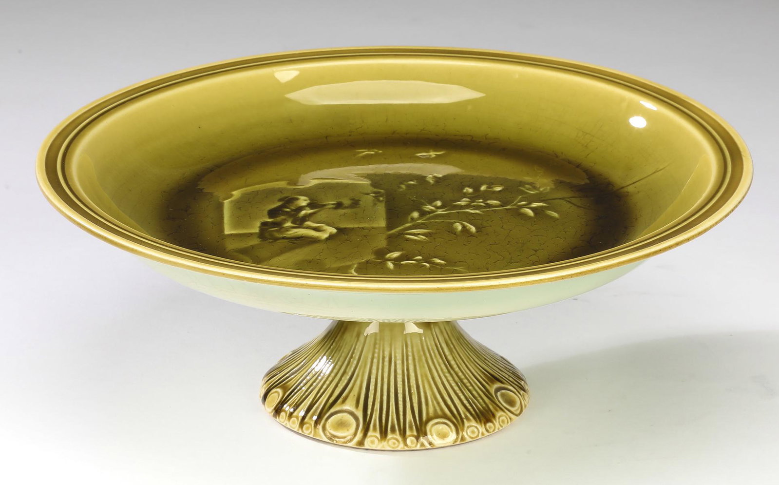 Late 19th c. Choisy-le-roi majolica cake stand: Choisy-le-roi majolica green Chinoiserie cake stand, late 19th century, having a round cake plate decorated with a kneeling scholar, a leafy branch, and birds, the whole rising on round geometric moti