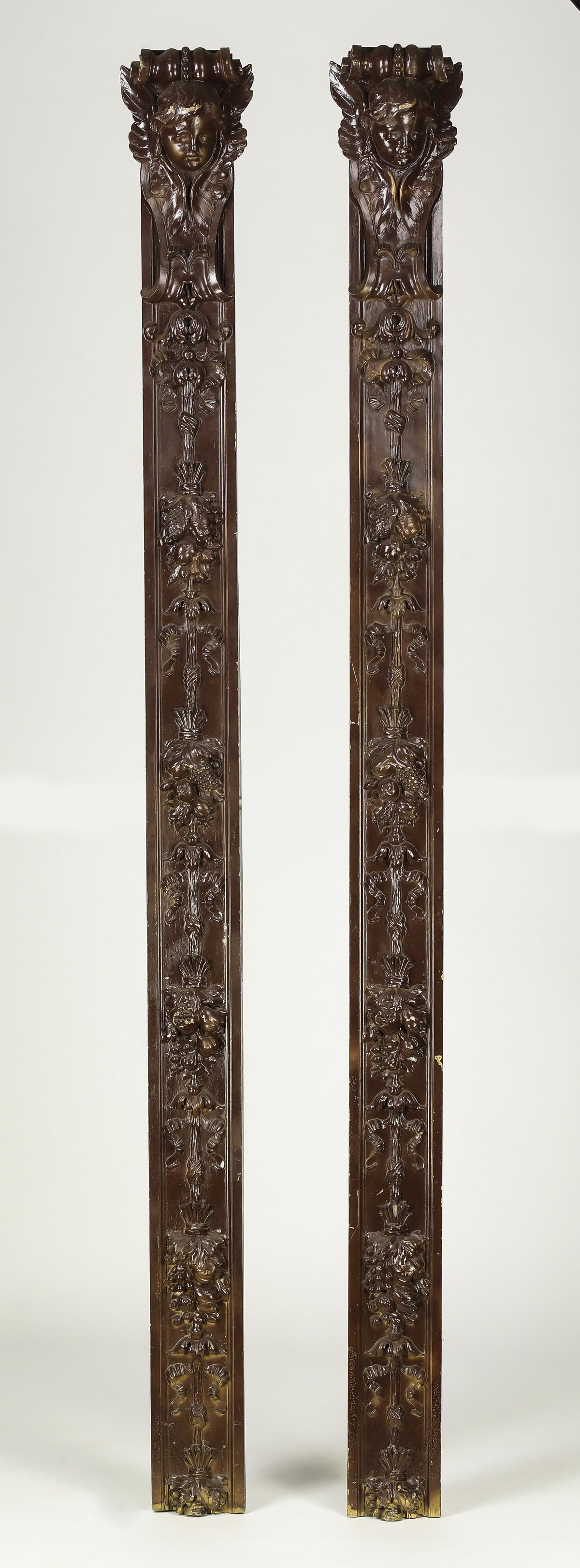 (2) Renaisssance Revival style architectural elements: Pair of Renaissance Revival style architectural pilasters, each of cast composite material, depicting a C-scroll capital above putto masks, rising on the standard of ribbons, garlands, and fruit arran