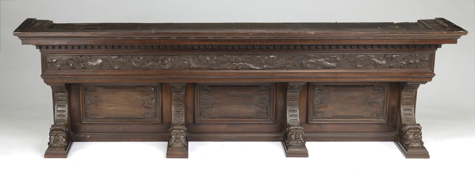 19th c. Northwind carved architectural element. 89"l: American Renaissance Revival carved walnut architectural element, late 19th to early 20th century, of elongated rectangular form, having a shaped cornice with a band of dentil molding over a band of c