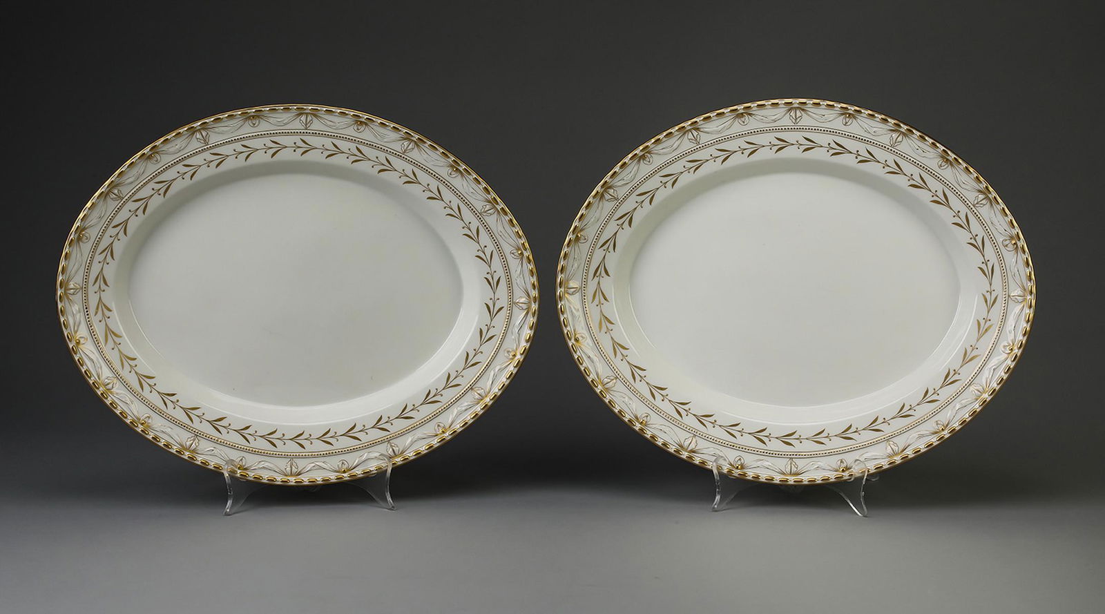(2) KPM ‘Kurland Gold' oval serving platters: (2) KPM porcelain oval serving platters in the ‘Kurland Gold’ pattern, early 20th century, originally designed by Johann Karl Riese circa 1790, having concentric bands of gilt beads, drapery jabot