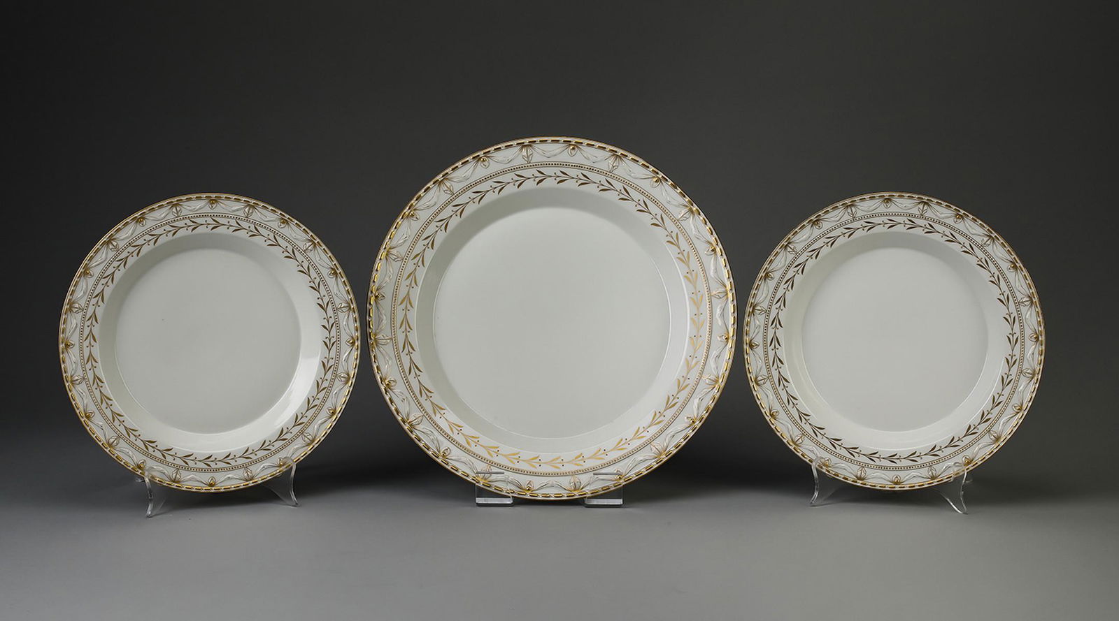 (3) pcs KPM ‘Kurland Gold’ round serving platters: (3) pcs KPM porcelain round serving platters in the ‘Kurland Gold’ pattern, early 20th century, originally designed by Johann Karl Riese circa 1790, having concentric bands of gilt beads, drapery