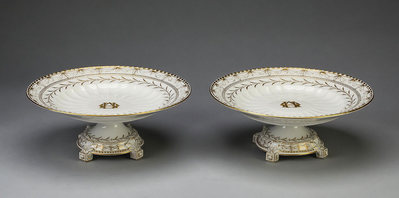 Pair of KPM ‘Kurland Gold’ compotes: Pair of KPM porcelain compotes in the ‘Kurland Gold’ pattern, early 20th century, originally designed by Johann Karl Riese circa 1790, having concentric bands of gilt beads, drapery jabots, and li