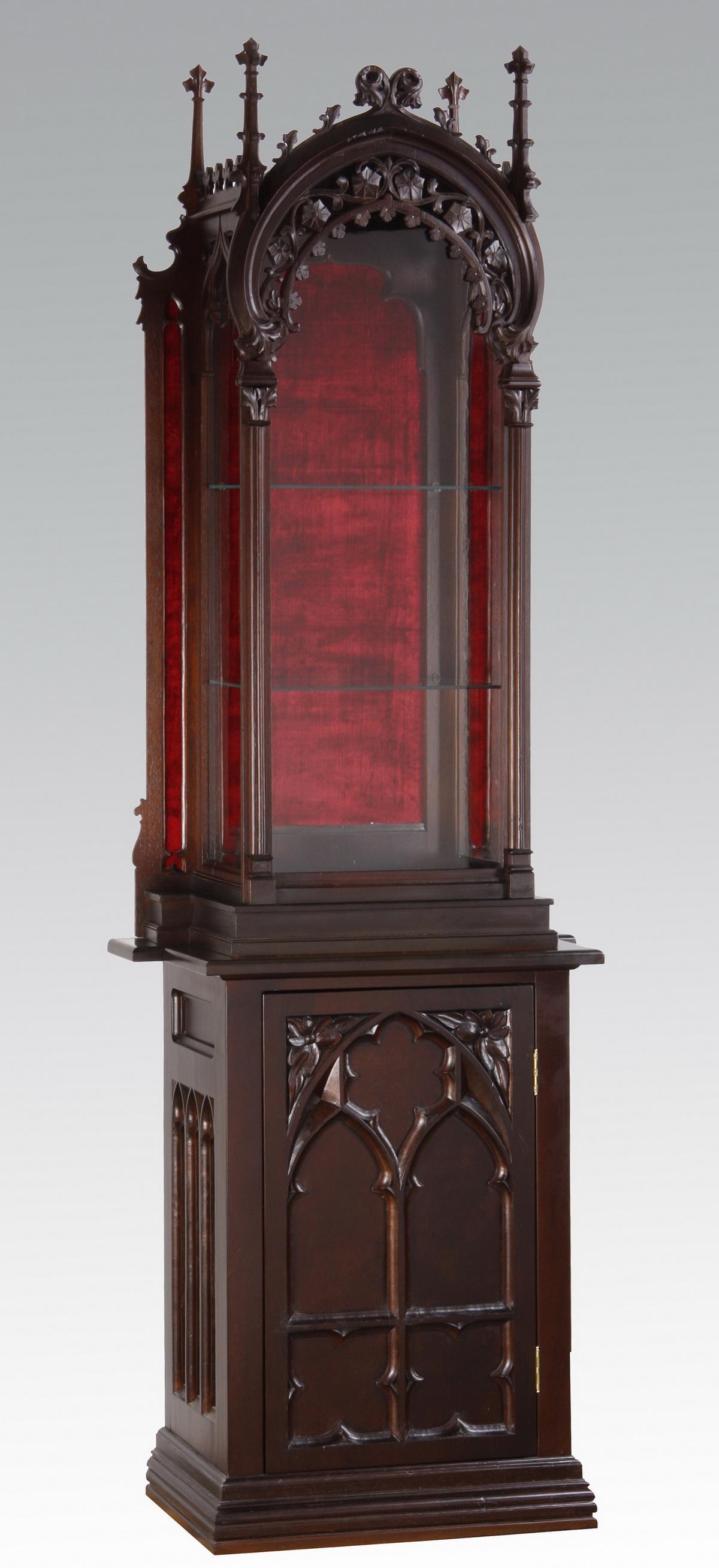 19th c. Gothic Revival walnut vitrine: Late 19th century Gothic Revival carved walnut vitrine on later base cabinet, the upper portion with a pierce carved foliate arch surmounting a glass paneled door, the sides with simplified arches sur