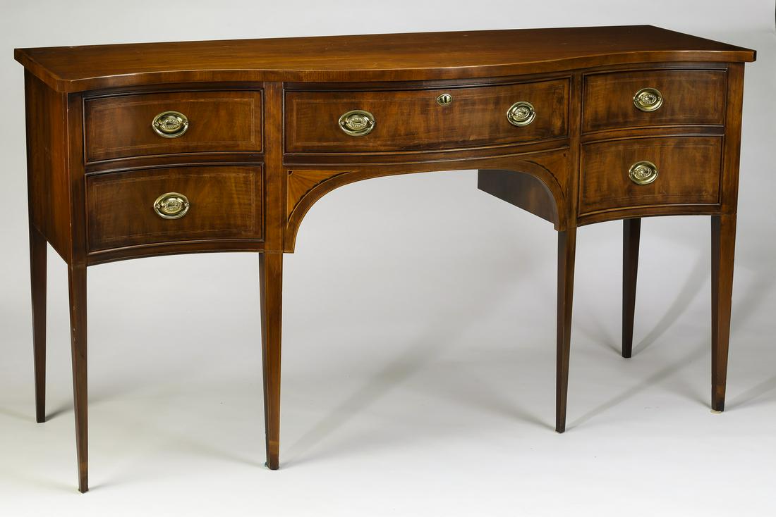Sheraton style mahogany sideboard, 68"l: Sheraton style mahogany sideboard, having a serpentine top surmounting a conforming case with two drawers on each side of a long center drawer, with oval pulls and string inlay, above fan inlays frami
