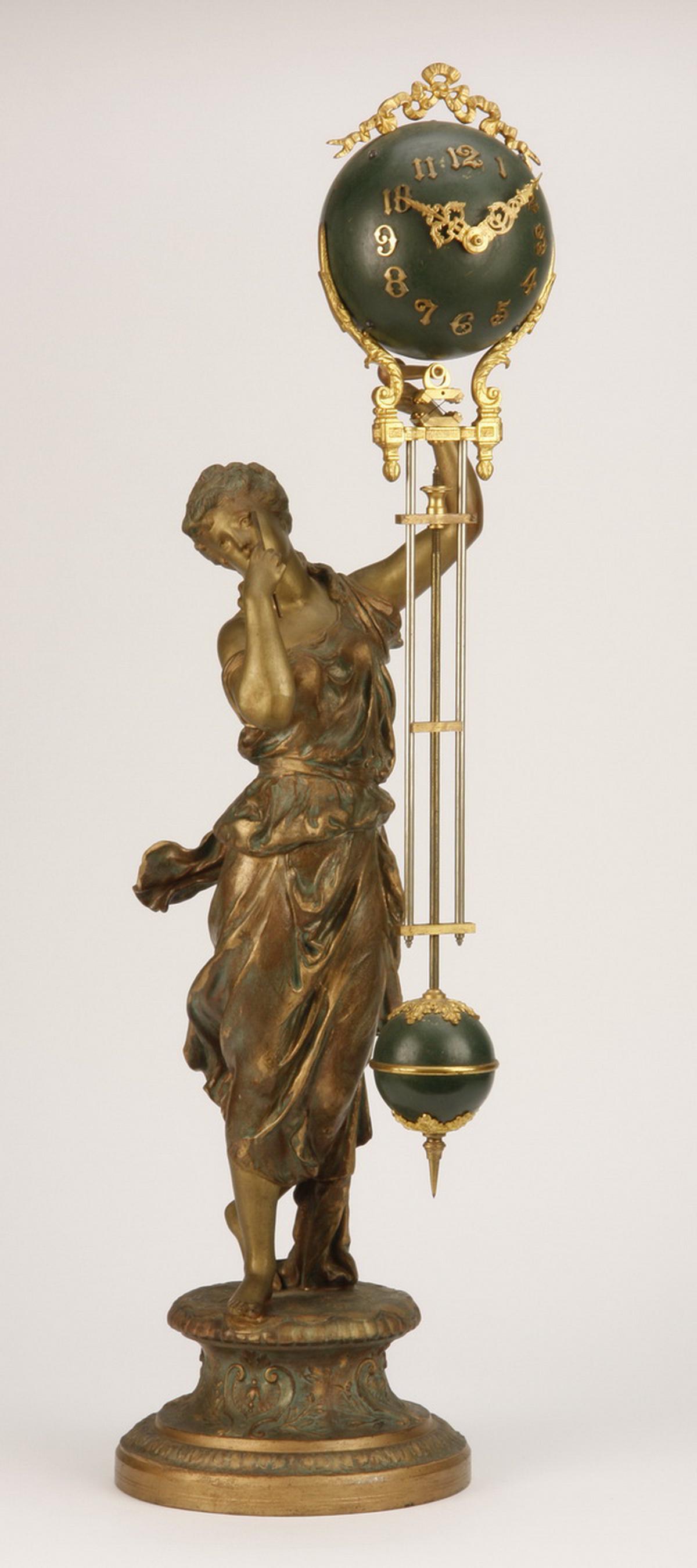 19th c. figural French swinger clock, 28"h: Late 19th century French gilt metal figural swinger clock in the form of a maiden holding aloft an oversized sphere shaped clock with attached pendulum, 28"h x 7.5" diameter.