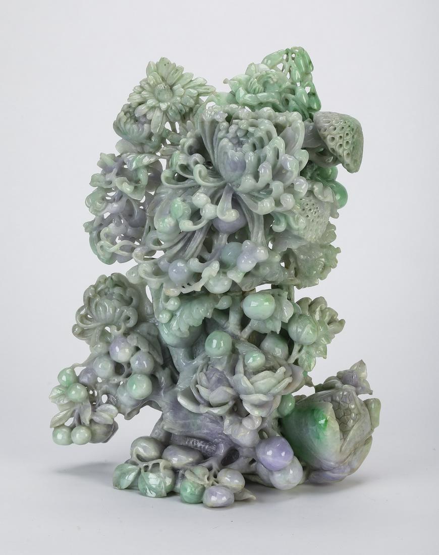 Chinese carved jade auspicious flower sculpture, 12"h: Chinese carved jade sculpture depicting auspicious flowers and plants, executed in lavender and celadon jade, having hibiscus and chrysanthemums, interspersed with bamboo fungus and grapes, the whole 