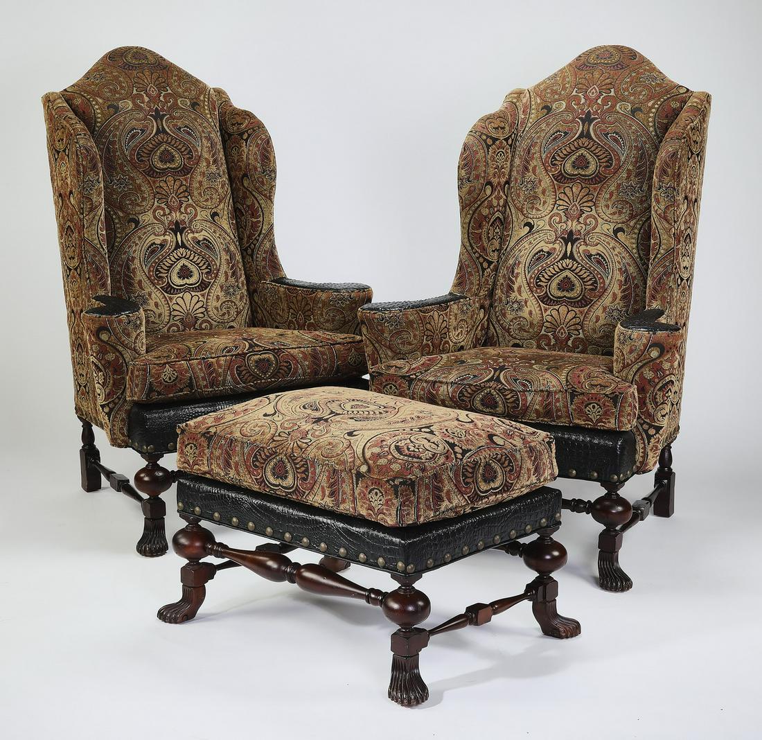 Wingback chairs and ottoman with tapestry upholstery: Pair of wingback chairs in the Louis XIII taste, pomegranate tapestry woven upholstery with faux embossed leather accents, and oversized nailhead trim, each having a chapeau gendarme crest and vertica
