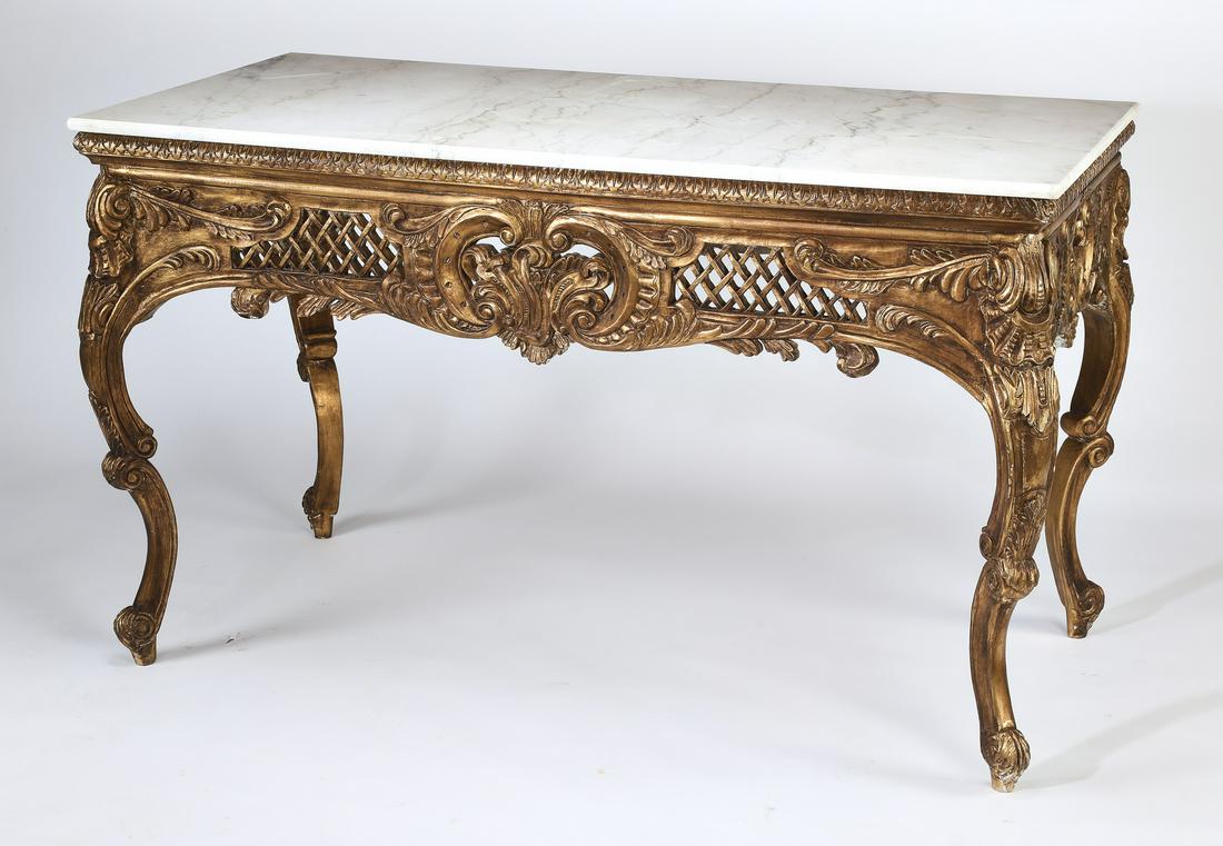 Louis XV style marble top giltwood center table: White marble and gilt wood ccenter table in the Louis XV taste, having a rectangular top, over a pierced and carved apron, centering a cartouche flanked by trellis work, rising on ornamented cabriole 
