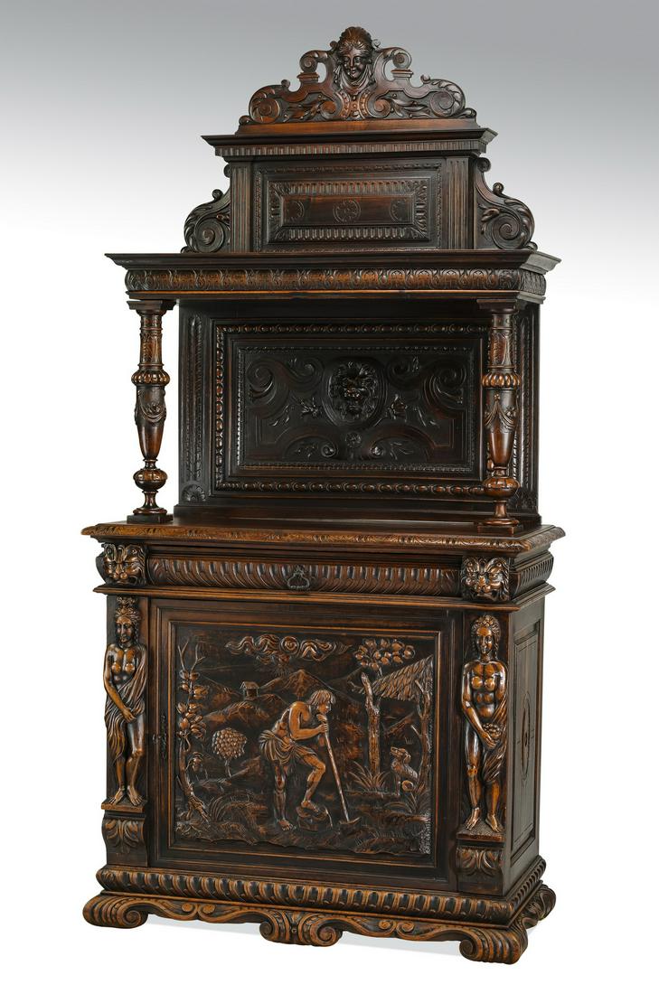 Early 20th c. French carved oak cabinet: French Renaissance Revival style oak cabinet, late 19th or early 20th century, having a figural mask and scrollwork pediment, rising on a molded and relief carved panel and open shelf, above turned an