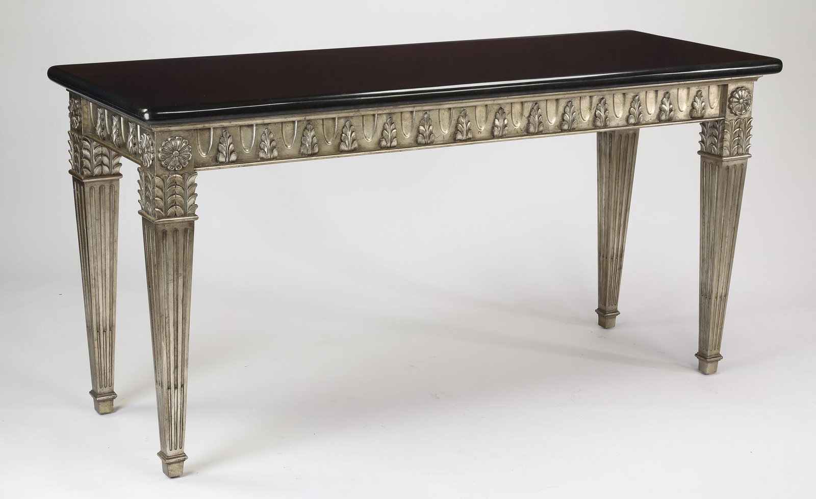 Empire style granite and carved wood console table: Empire style granite and carved wood console table, having a rectangular black granite top above a silvered base with a wide apron carved with foliate palms, the whole rising on square fluted tapering