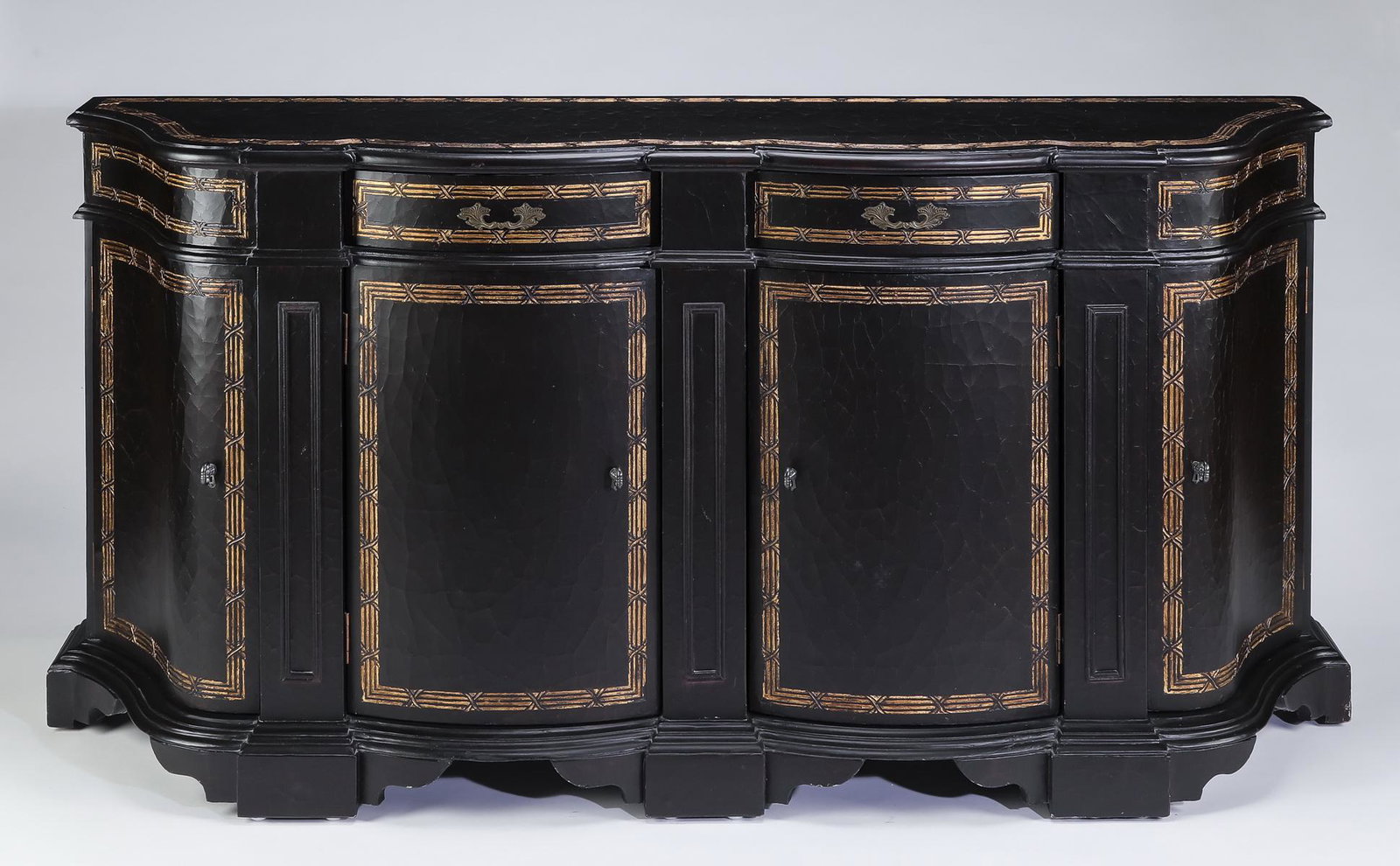 Parcel gilt and distressed ebonized cabinet: Parcel gilt and distressed ebonized cabinet, having a rectangular top with ogee shaped front over a conforming cabinet, surmounting two frieze drawers above two curved doors opening to shelves, flanke