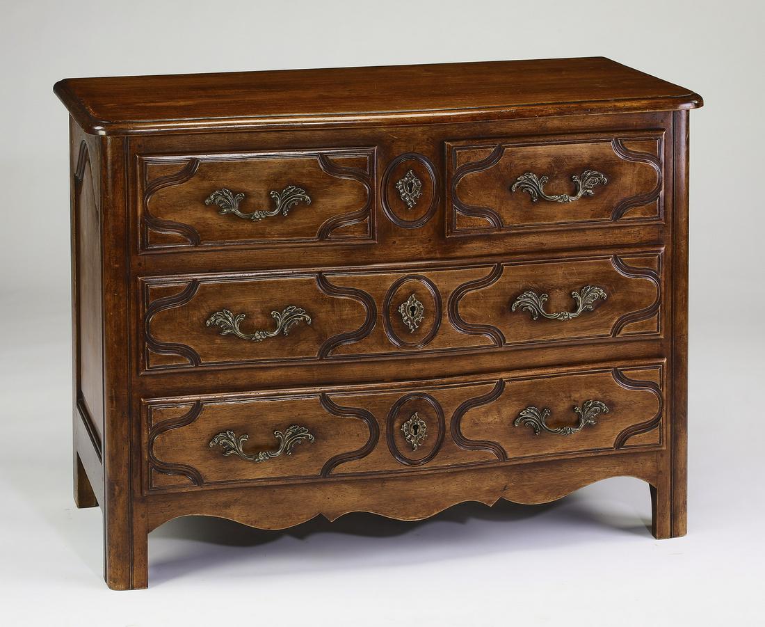 Early 20th c. French Provincial style commode: French Provincial style walnut commode, early 20th century, having a serpentine top over a rectangular case, fitted with two short over two long drawers, ornamented with a shaped skirt, the whole risi