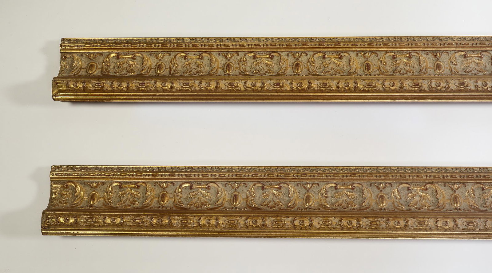 (2) Italian carved and gilt decorative moldings, 118": Pair of Italian carved and gilt decorative moldings, having three borders of acanthus leaves, each measuring 4"h x 118.5"l x 2"d.