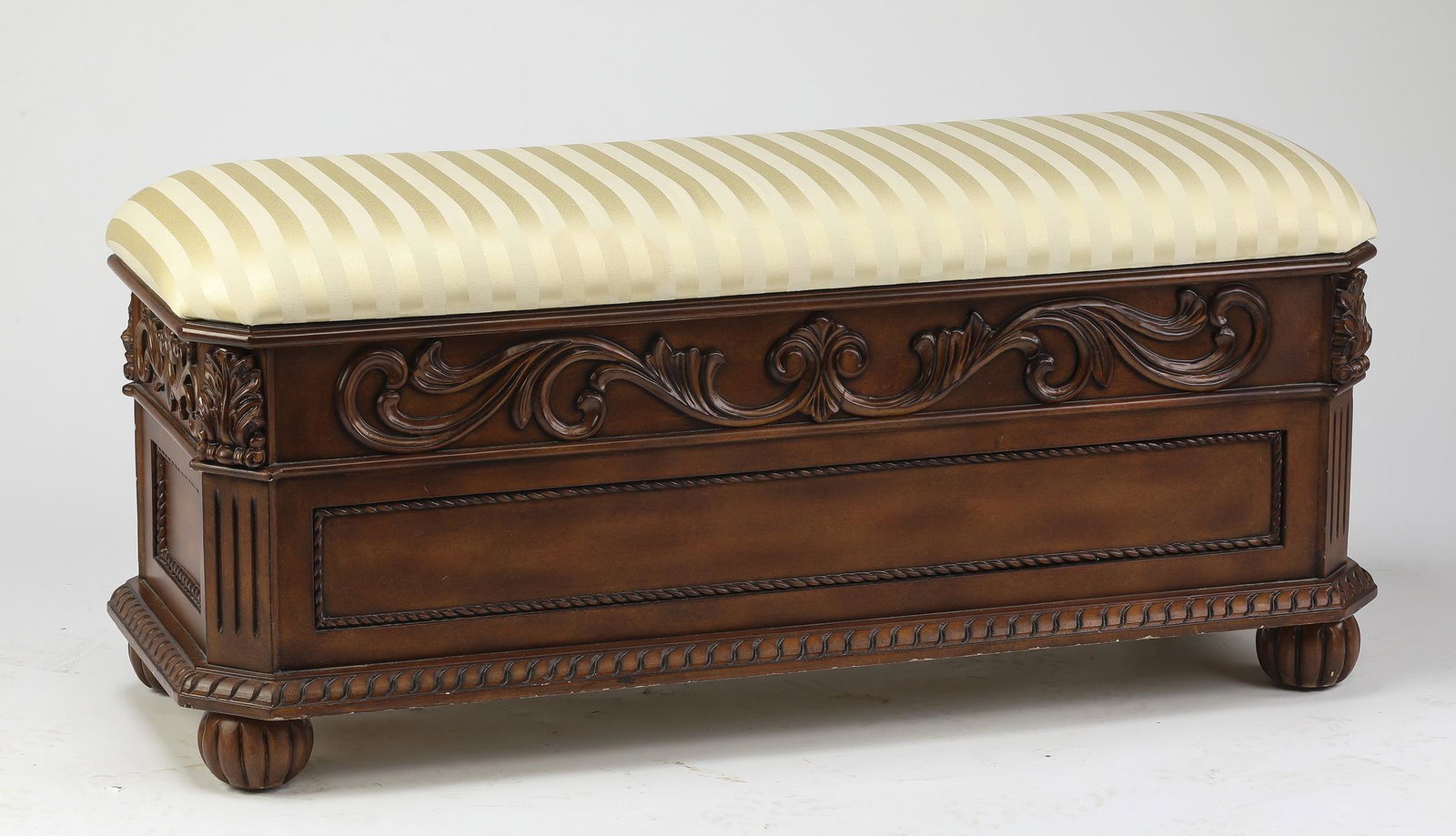 Carved bench with storage and upholstered top: Carved bench with storage in the Renaissance taste, having a padded and upholstered rectangular top with canted corners, opening to storage with soft close hinges, above a conforming case with a carve
