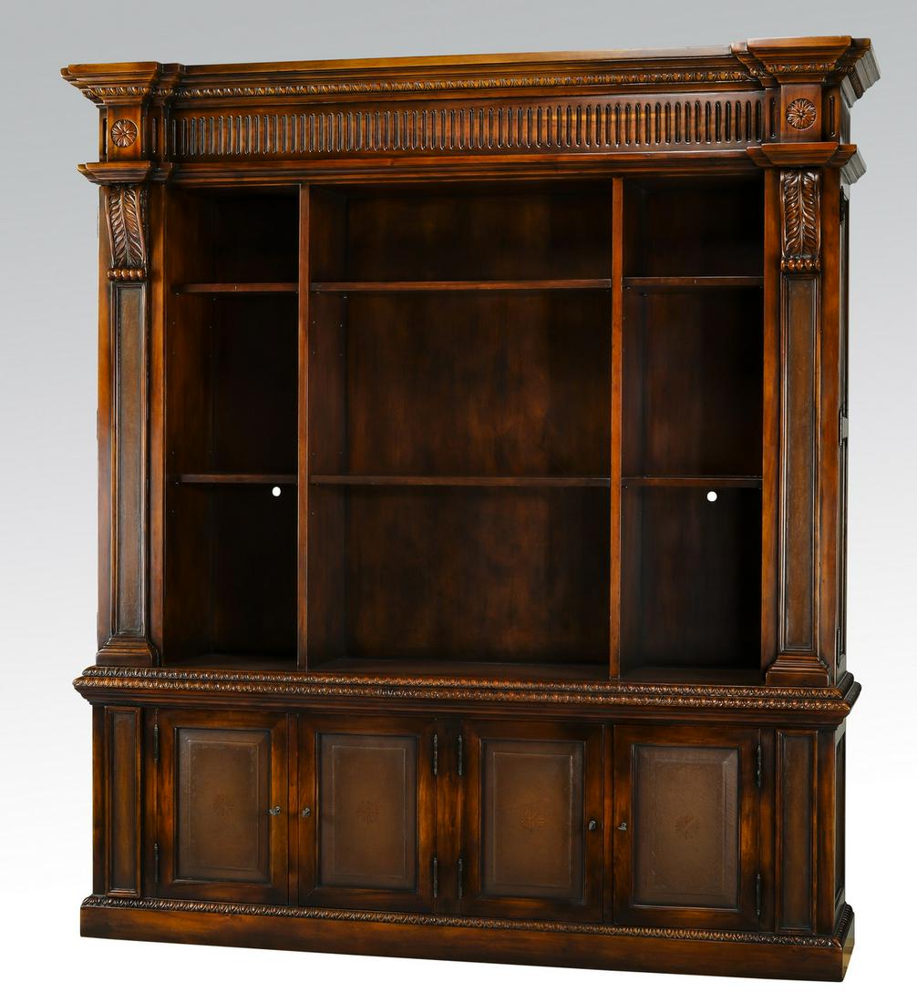 Neoclassical inspired leather and mahogany bookcase: Neoclassical inspired leather and mahogany bookcase, having a molded and fluted cornice carved with rosettes above the conforming tripartite open shelves, flanked by columnar doors, surmounting a lowe