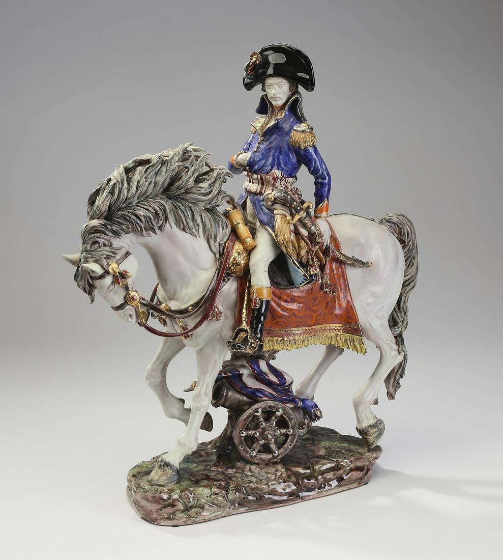 Hand painted Capodimonte style Napoleon on horseback: Signed, hand painted Capodimonte style figure of Napoleon on horseback, depicting the French emperor astride a horse with one hand tucked inside his jacket, resting on an oval base with a flag wrapped
