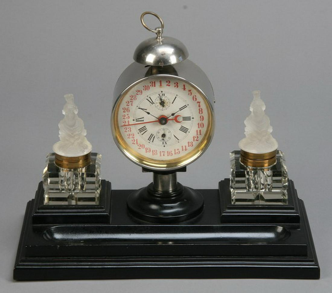 French Art Deco ebonized and crystal desk set: French Art Deco ebonized wood desk set featuring a pair of heavy cut crystal inkwells with Lalique-style moulded crystal covers depicting Neoclassical maidens, flanking a round central clock, 12"h x 1