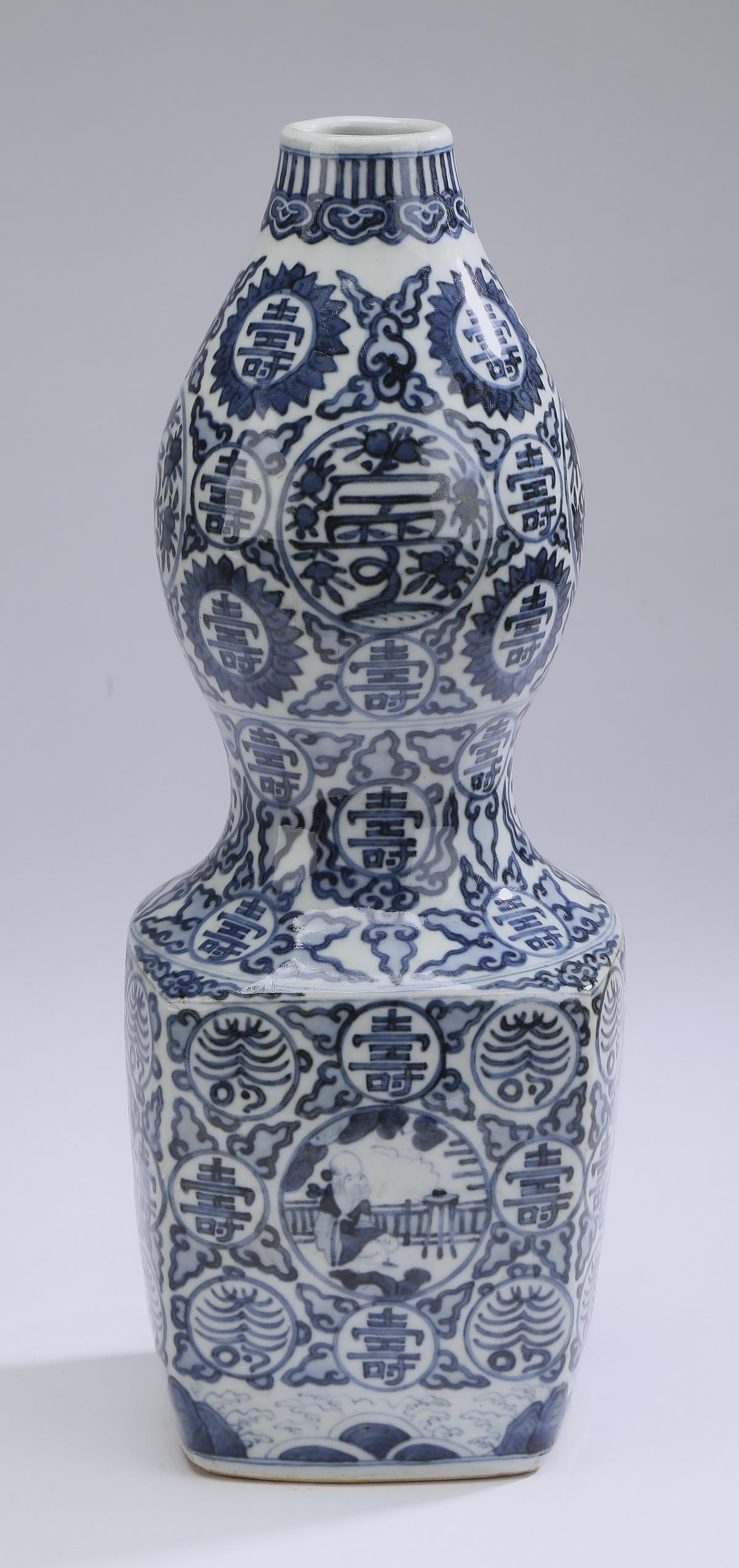 Chinese Ming style squared double gourd vase: Chinese Ming style blue and white squared double gourd vase, having a ruyi band at the rim above a top gourd with four reserves depicting stylized flowers, and a bottom gourd with four reserves depict