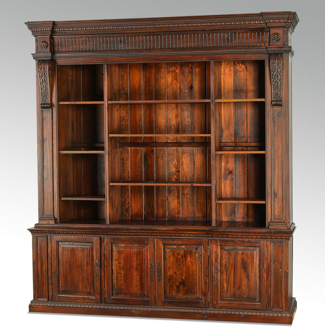Neoclassical style carved bookcase, 85"w: Neoclassical style carved bookcase, having a gadrooned and Greek key cornice rising over the tripartite case, each section having three shelves, the whole flanked by acanthus carved stiles, rising on 