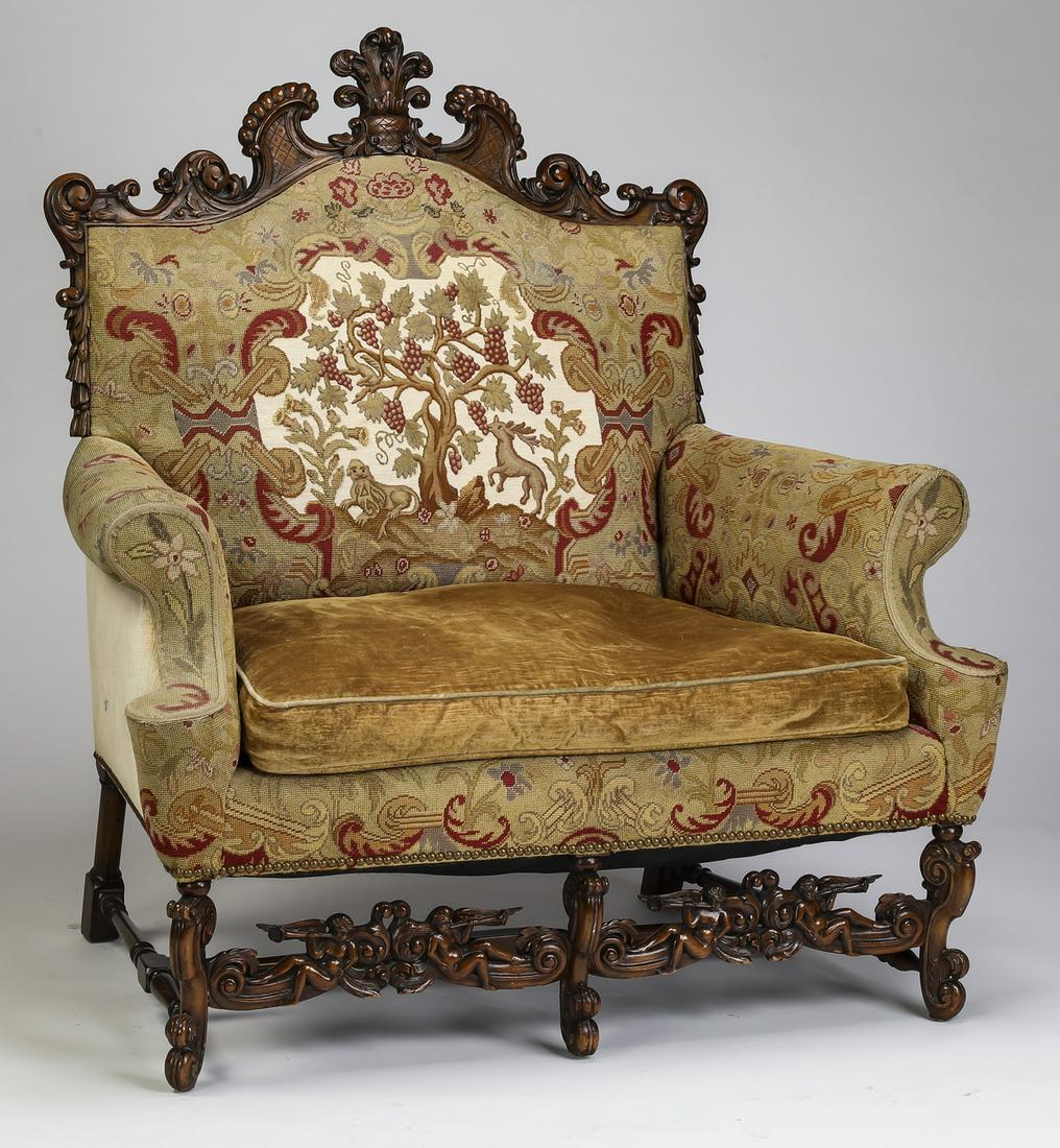 Oversized 19th c. walnut bergere in needlepoint: Oversized 19th century Continental Baroque Revival walnut bergere upholstered in needlepoint, having a chapeau gendarme shaped back with carved foliate crest centering a feather cartouche with a centa