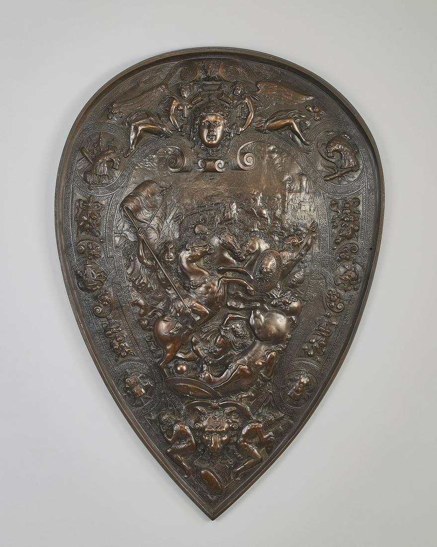 Early 20th c. bronze shield, St, George w/ dragon: Decorative bronze shield in the Renaissance taste, early 20th century, of ancient gothic form with rounded crest tapering to a point, centering St. George slaying the dragon, 26"h x 18"w x 2"d.