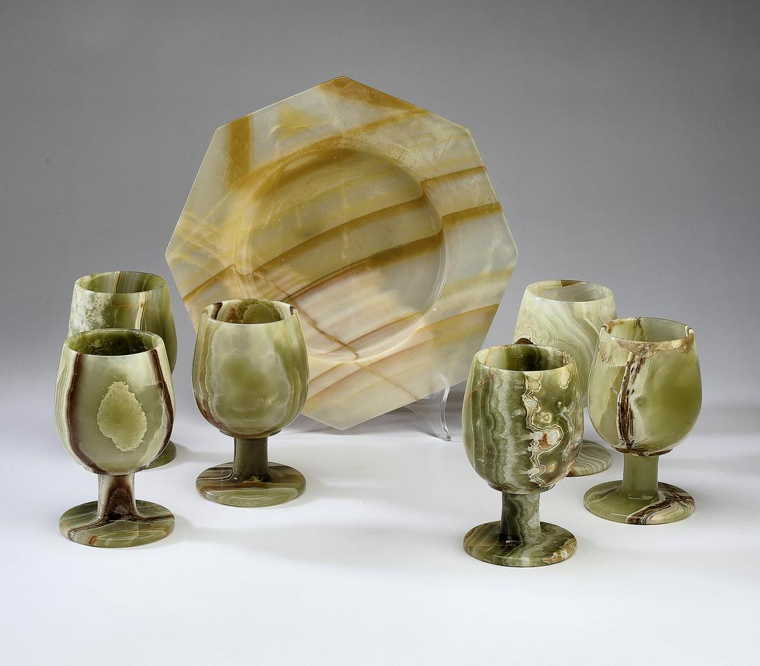 (7 pcs) Onyx table articles, goblets and plate: Group of (7) onyx table articles, comprising: (6) wine goblets, each having an ovoid bowl rising on a cylindrical stem terminating to a flanged circular foot, 5"h x 3"dia; and (1) octagonal plate with