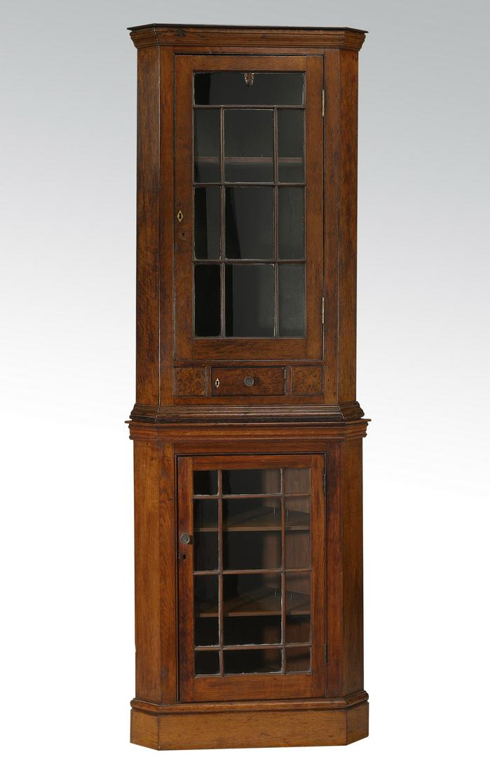 19th c. American oak and burl wood corner cupboard: American two piece oak and burl wood corner cupboard, 19th century, the top section having a molded cornice and glass doors, opening to adjustable shelves, over a small solid burl wood door, the botto
