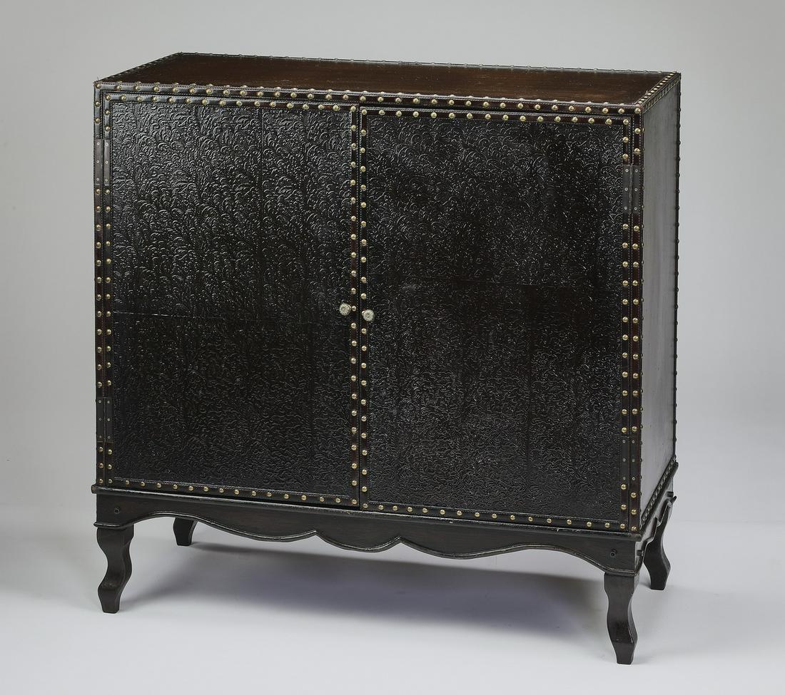 Embossed faux leather campaign cabinet, 36"w: Embossed faux leather campaign cabinet, having a rectangular top over a conforming cabinet fitted with two doors with nailhead trim, opening to one fixed shelf, the whole rising on short cabriole legs