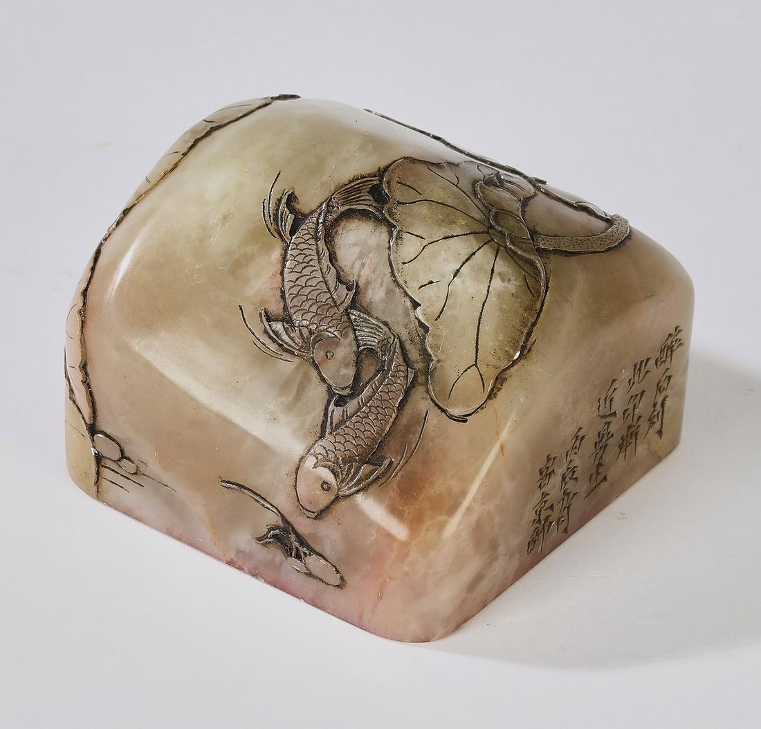Lotus pond shoushan soapstone chop, 2.5"sq: Lotus pond shoushan soapstone chop, the top relief carved with lotus leaves and carp, one side having a carved text, and the underneath with vestiges of red pigment, 1.75"h x 2.5"sq.