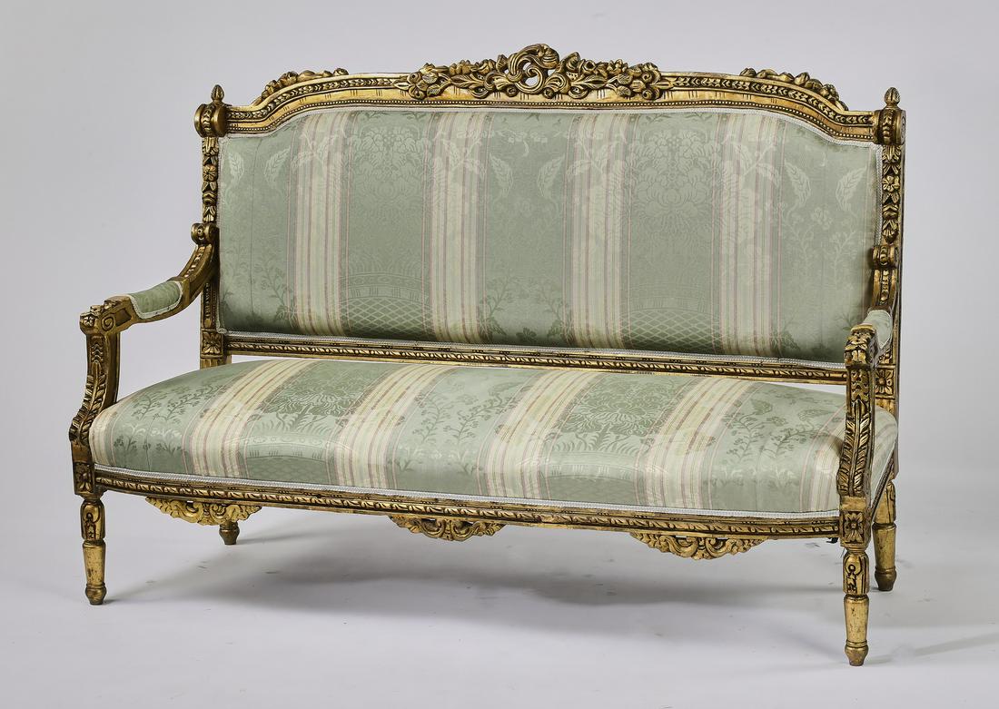Italian gilt wood sofa upholstered in damask: Italian gilt wood Louis XVI style sofa, having an arched and pierced acanthus scrollwork crest flanked by finials, rising on the back rest upholstered in sage and cream damask, flanked by scrolling pa