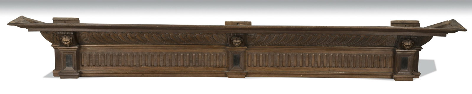 19th c. carved walnut architectural cornice, 122"l: 19th century Neoclassical style carved walnut architectural cornice, the gadrooned molding interspaced with three lion's masks above the dentil frieze, 25"h x 122"l x 19"d.