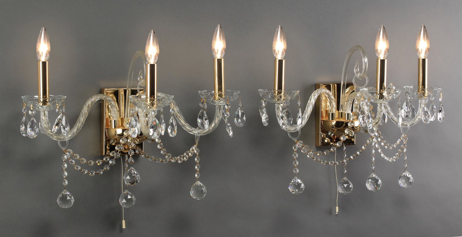 (2) Murano style three-light sconces, 16"h: Pair of Murano style three-light sconces, executed in glass, crystal, and brass, each having a glass plume ending in a ring above three sinuous glass sheathed arms ending in bobeches and hung with bea