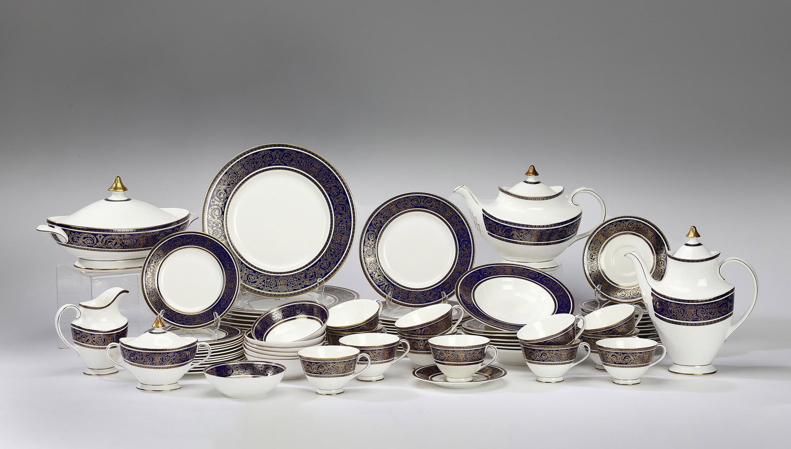 (78 pcs) Royal Doulton 'Imperial Blue' dinner service: Royal Doulton dinner service in the ‘Imperial Blue’ pattern, having a cobalt blue enamel rim ornamented with intricate gilt arabesques on a cream ground, maker marked, comprising: (12) dinner plat