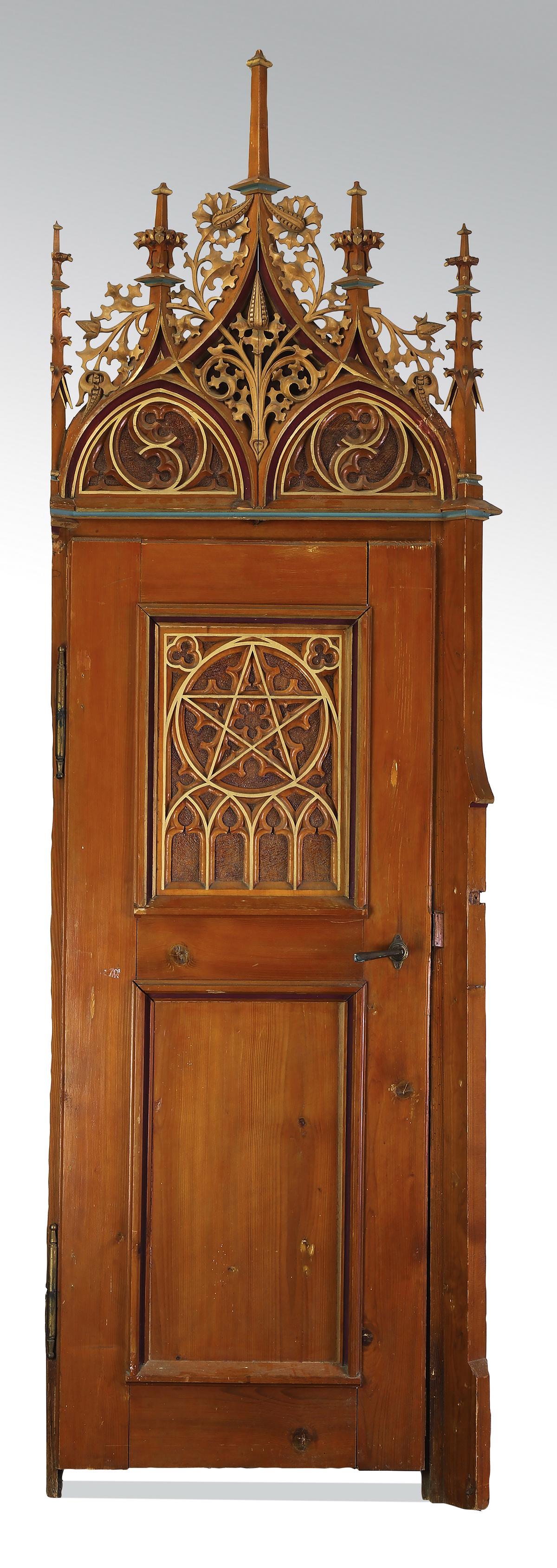 Gothic Revival style door and ornamented surround: Gothic Revival style parcel gilt and paint decorated architectural element comprising a door and ornamented surround, having a pierced and carved foliate pediment flanked by buttress finials over a do