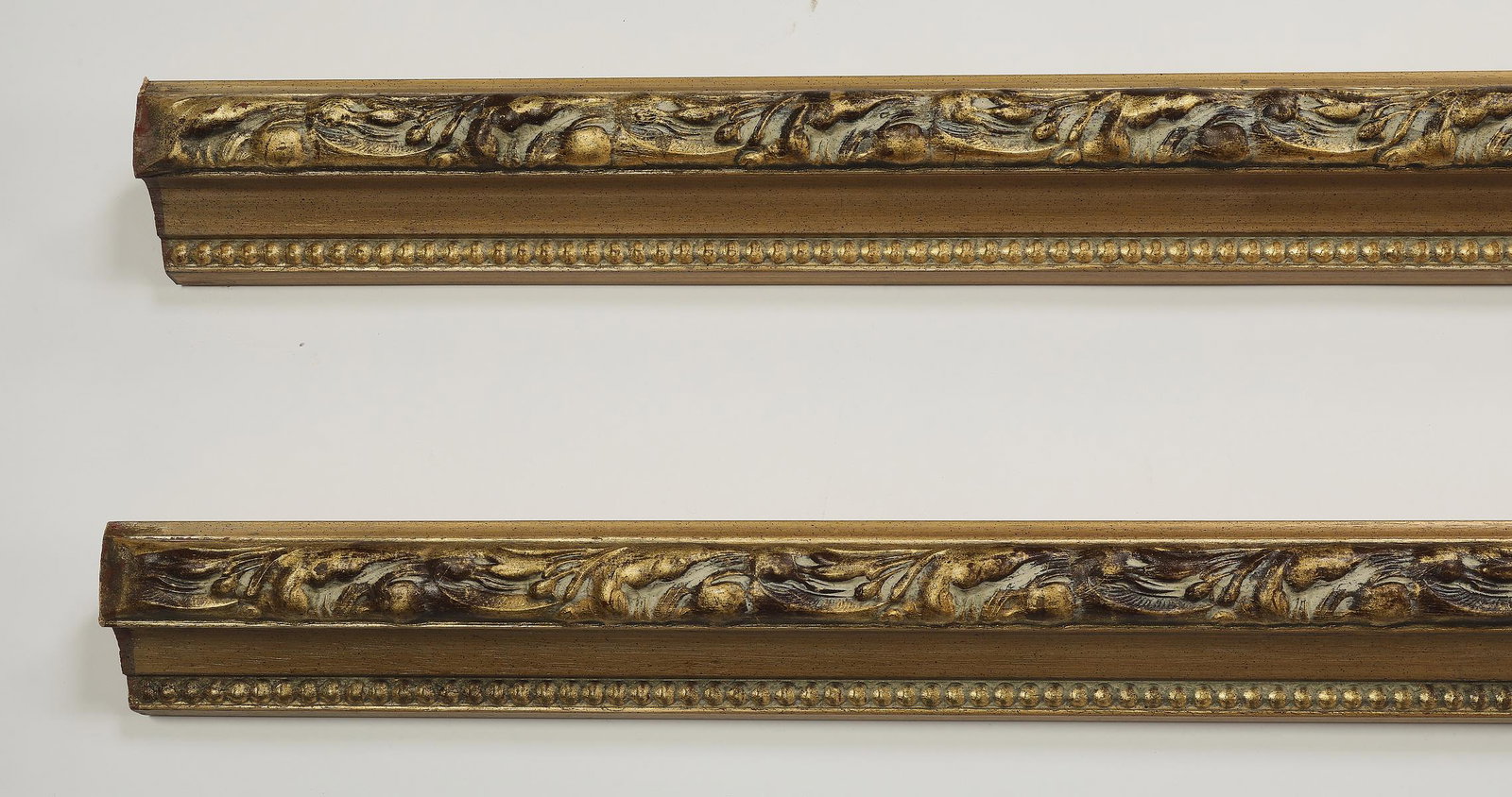 (2) Italian carved and gilt decorative moldings 119"l: Pair of Italian carved and gilt decorative moldings, each with an acanthus scrollwork and beaded border, measuring 3.5"h x 118.5"l x 3"d.