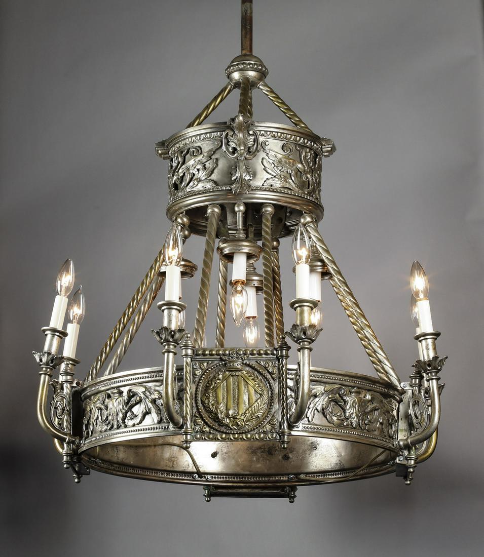 19th c. Continental bronze chandelier w/ coat of arms: Continental silvered bronze 12-light chandelier in the Renaissance taste, late 19th or early 20th century, having a two tiered circular frame each decorated with repousse rinceau and mythological crea