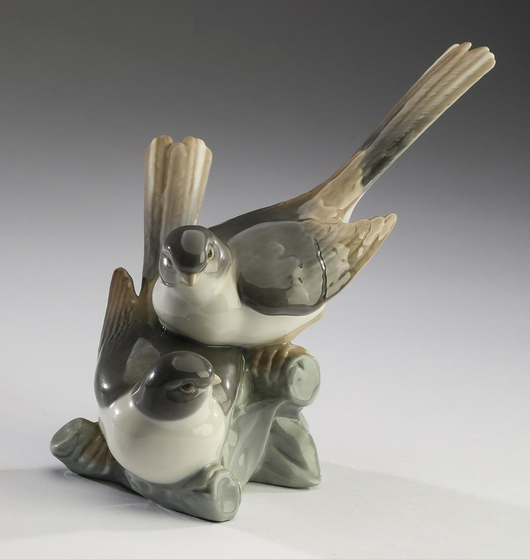 Retired Lladro 'Birds' porcelain figurine #4667, 9"w: Retired Lladro 'Birds' porcelain figurine #4667, circa 1970-1985, depicting a pair of white, tan, and grey birds perched close together on a knotted branch, maker's mark to underside, 7.5"h x 9"w x 7"