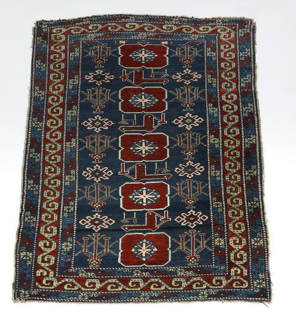 Hand knotted wool Caucasian Shasavan rug, 5 x 4: Hand knotted wool Caucasian Shasavan rug, having repeating crimson medallions interspaced with animal motifs flanked by guls on an indigo ground, with a meander border on a crimson ground, 4' 7"l x 3'