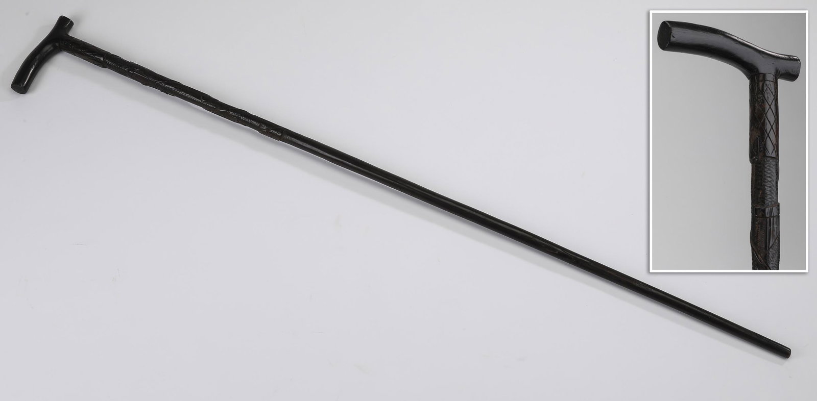 Carved ebonized wood walking stick, 36"l: Carved ebonized wood walking stick, having a Derby handle surmounting a shaft with relief carved trailing ivy leaves and tendrils decorating the upper third, 35.5"l.
