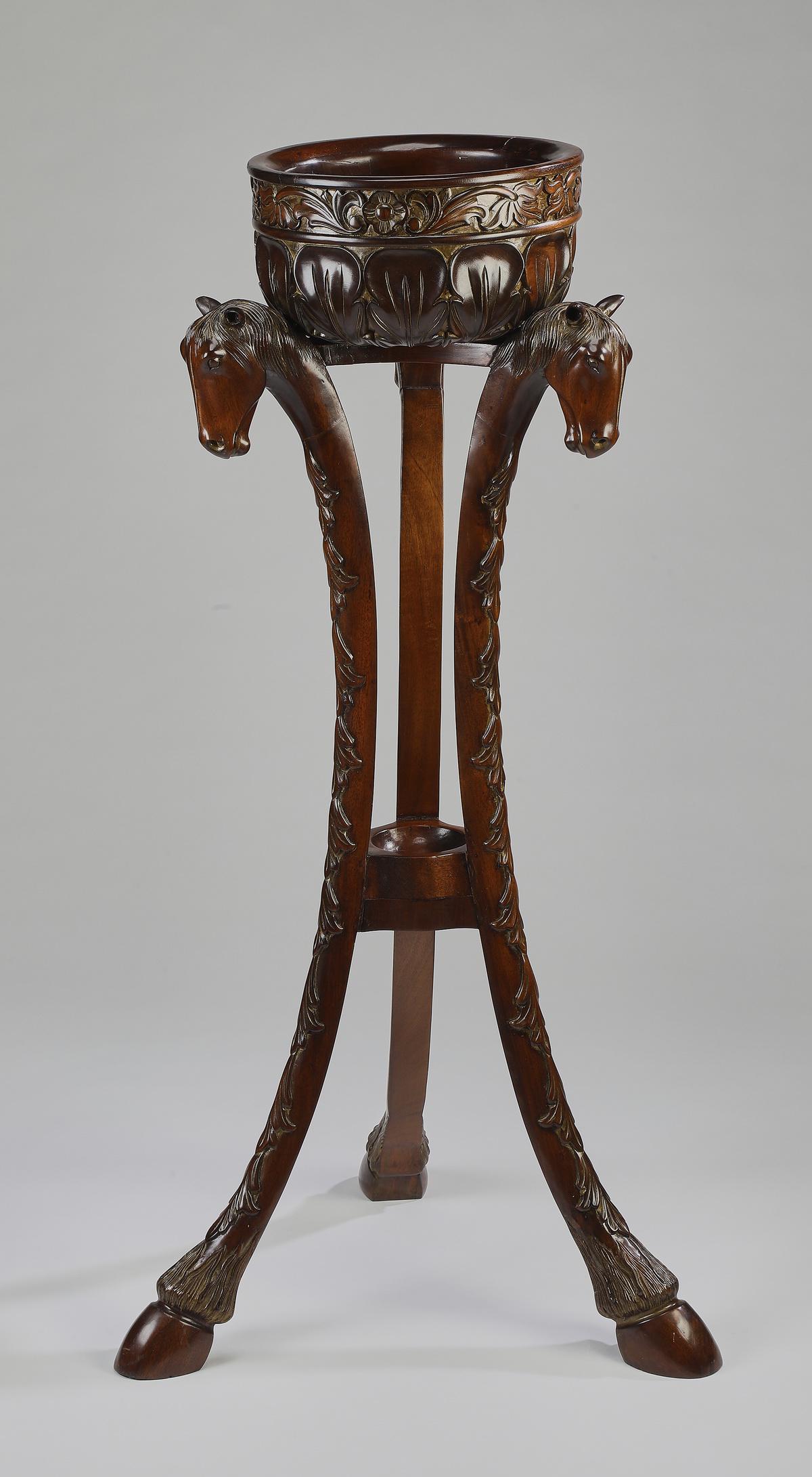 Carved mahogany figural jardiniere: Carved mahogany figural jardiniere, having a naturalistic motif carved bowl rising on three splayed legs carved with horse head figurals, terminating in hoof feet, 43"h x 22"dia, inside of bowl 9"dia.